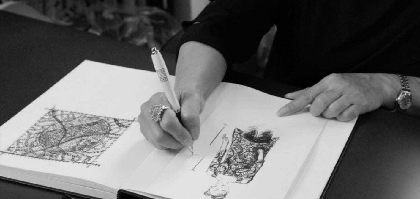 A designer drawing garment details in a sketchbook
